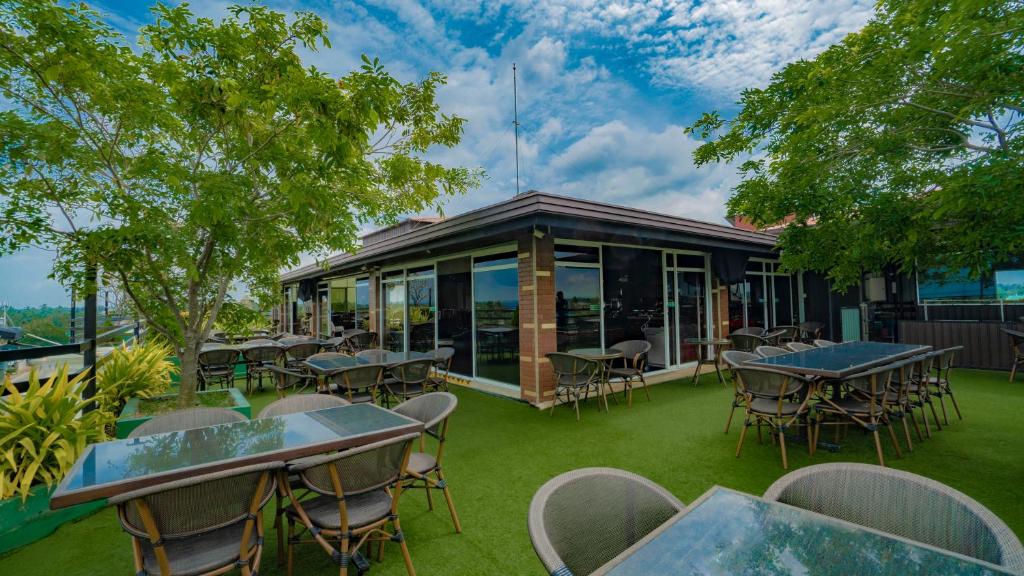 a patio with tables and chairs and a building at Sasha Transit Hotel in Katunayake