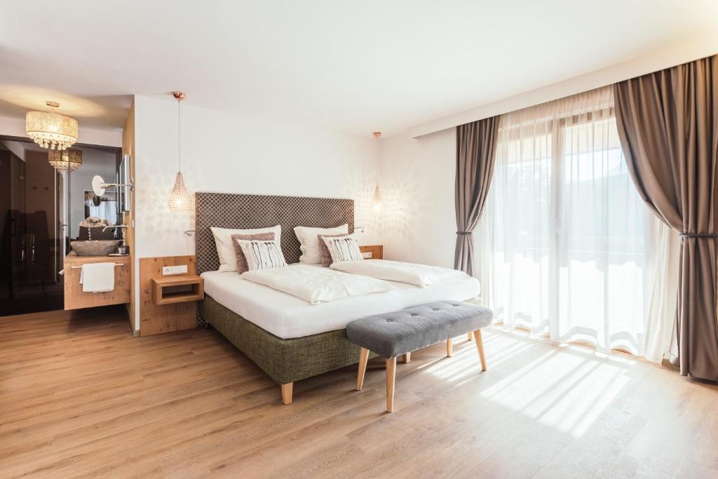 a bedroom with a large bed and a large window at Hotel VIKTORIAS HOME Kufstein in Kufstein