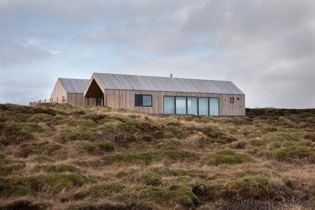 a wooden house on top of a hill at Luxury house, Golden Circle getaway - Private hot tub and sauna in Reykholt