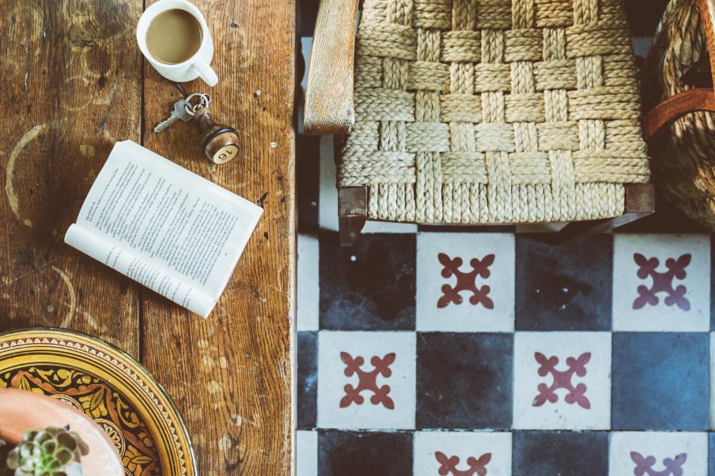 a table with a book and a cup of coffee and a chessboard at Hotel Le Ponteil in Antibes
