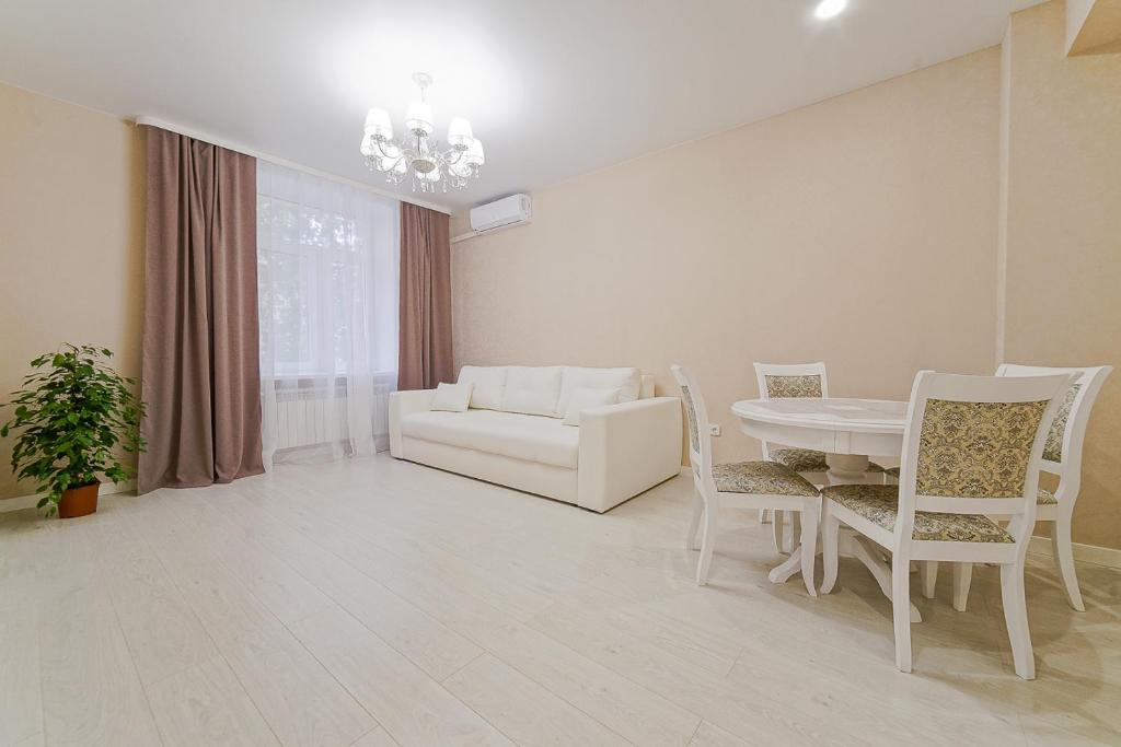 uma sala de estar com uma mesa e cadeiras e um sofá em Apartments on Krasnaya Street em Minsk