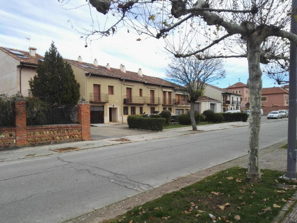 an empty street in a residential neighborhood with houses at Pequeño y Coqueto Piso en Riaza in Riaza