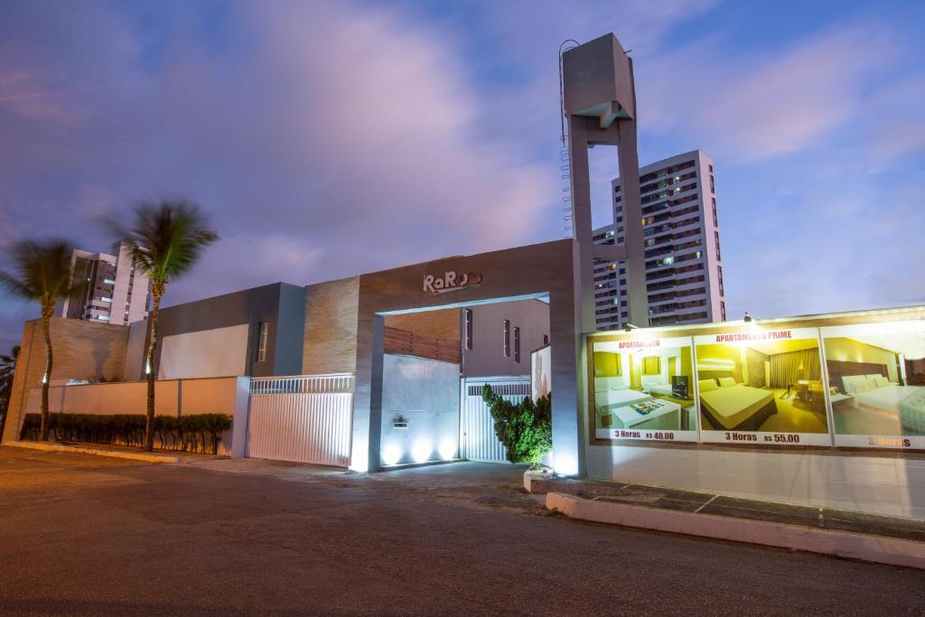 una tienda frente a un edificio con luces encendidas en Raru's Motel Cidade Jardim (Adult Only), en Natal