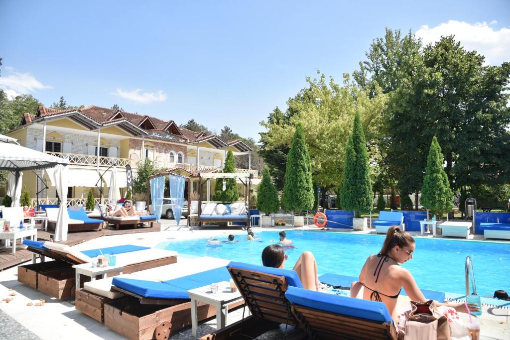 un gruppo di persone sedute in piscina di Krikonis Hotel a Ioannina