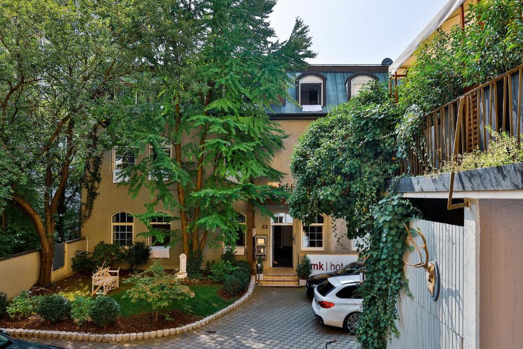 a house with a car parked in front of it at mk hotel münchen max-weber-platz in Munich