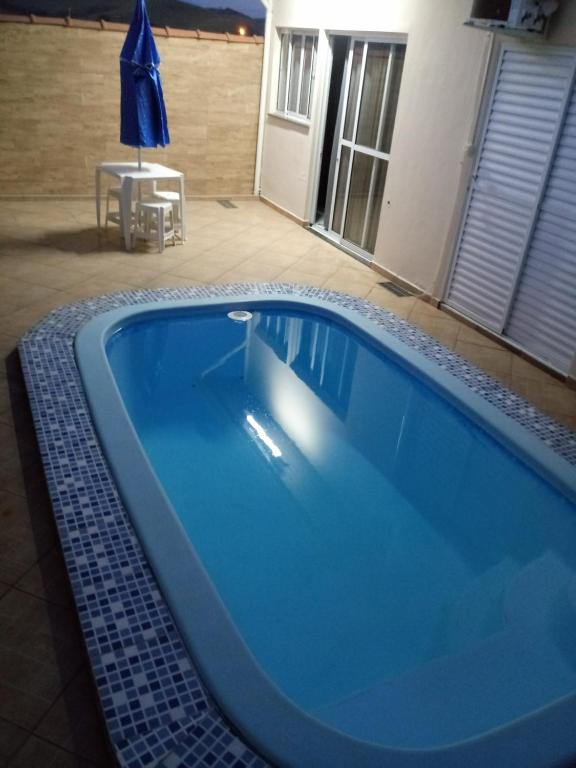 a large blue swimming pool in a house at Casa de Hospedagem em Cachoeira Paulista in Cachoeira Paulista