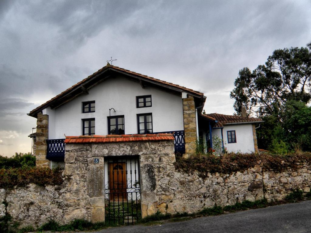 Casa blanca con pared de piedra en Casa Rural Ortulane, en Urduliz