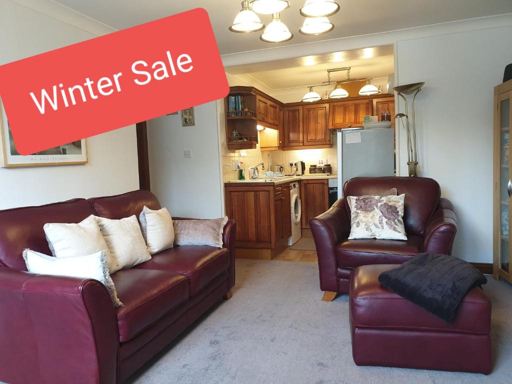 a living room with two leather couches and a winter sale sign at Lyndale Family Apt Winter Deals offered on 3 nts or more in Windermere