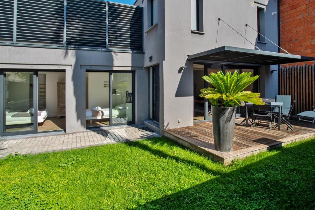 Cette maison dispose d'une terrasse avec une table et une plante. dans l'établissement La Dependance by Cocoonr, à Bordeaux