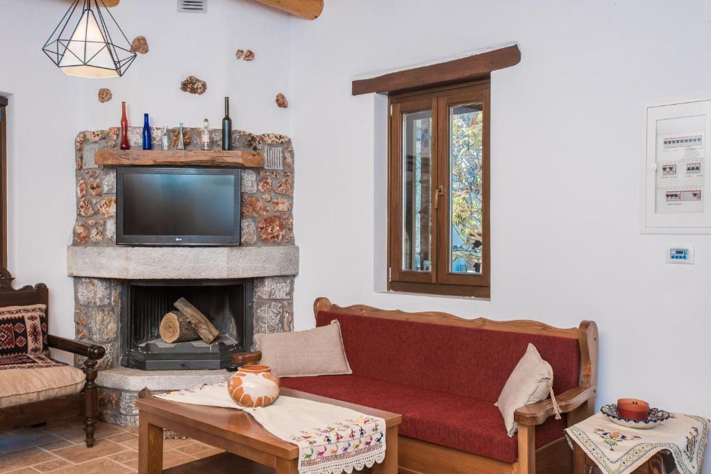 a living room with a red couch and a fireplace at ARADENA TRADITIONAL House 4 in Arádhaina