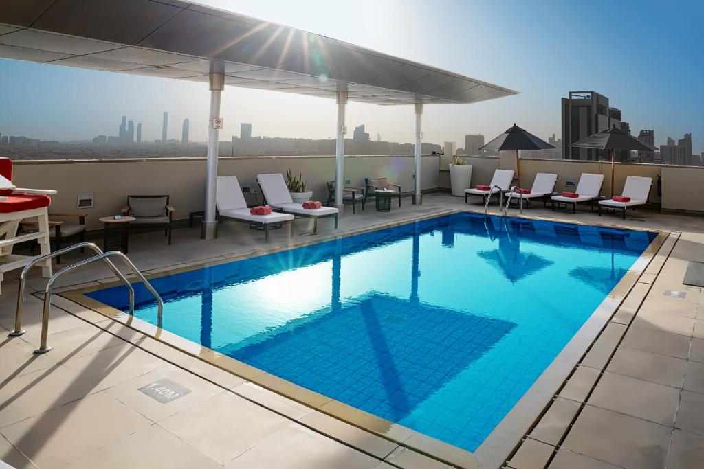 a swimming pool on the roof of a building at Centro Al Manhal by Rotana in Abu Dhabi