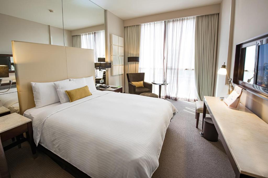 a hotel room with a large bed and a desk at Centro Al Manhal by Rotana in Abu Dhabi