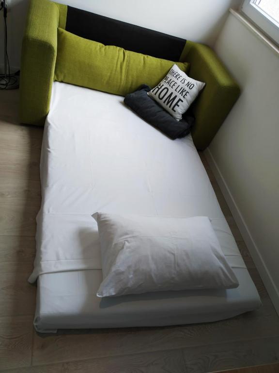 a white couch with two pillows on it at sky in Pula