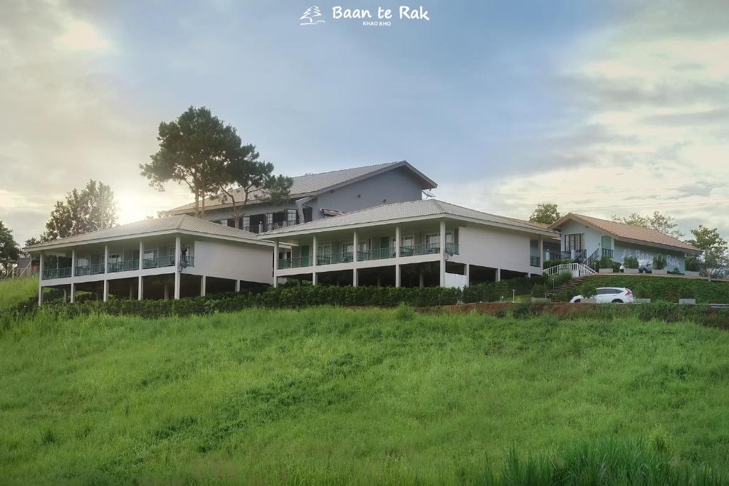 a large house on top of a green hill at บ้านที่รัก เขาค้อ Baan Te Rak in Phetchabun