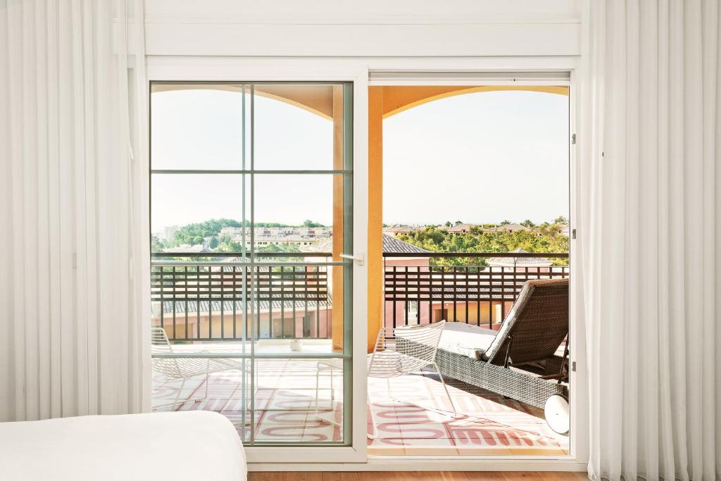 a room with a door open to a balcony at Ama Islantilla Resort in Islantilla