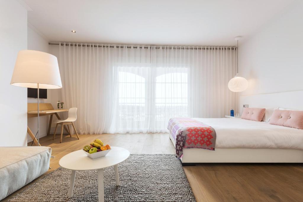 a bedroom with a bed and a couch and a table at Ama Islantilla Resort in Islantilla
