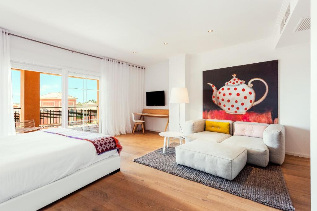 a bedroom with a large white bed and a couch at Ama Islantilla Resort in Islantilla