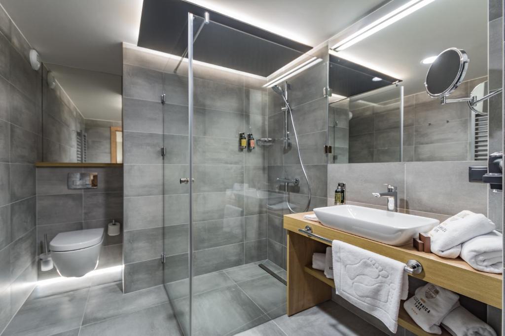 ein Badezimmer mit Dusche, Waschbecken und Toilette in der Unterkunft Szczawnica Park Resort & Spa in Szczawnica