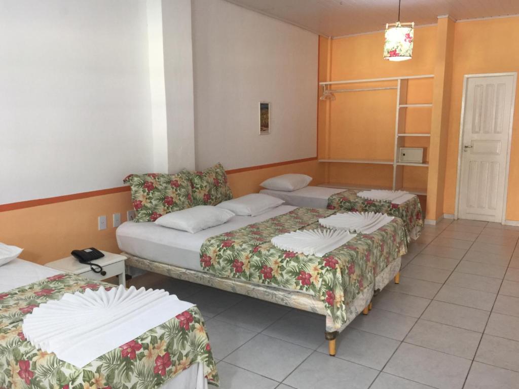 a hotel room with two beds and a table at Capitania Praia Hotel Fazenda in Porto Seguro