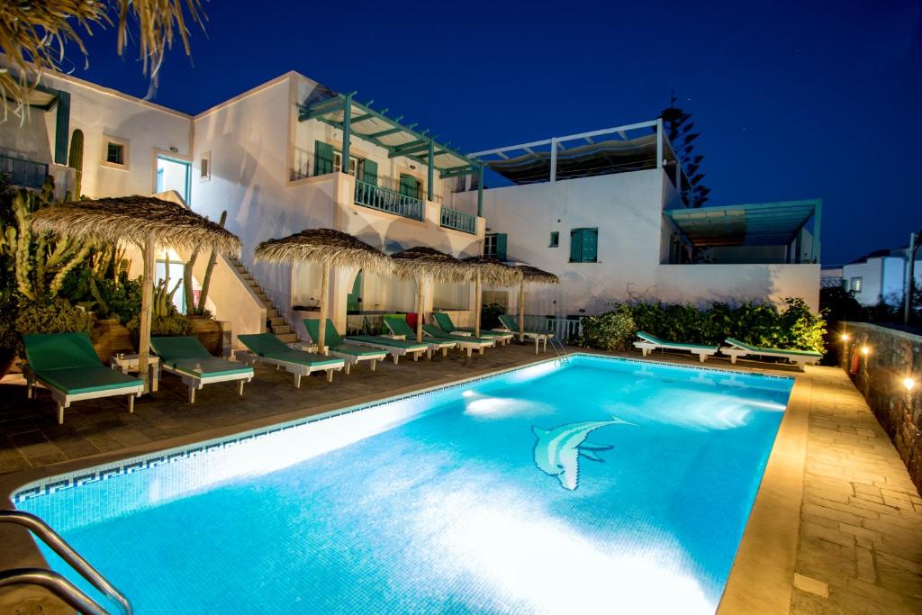a swimming pool in front of a house at night at Hotel Andreas in Kamari