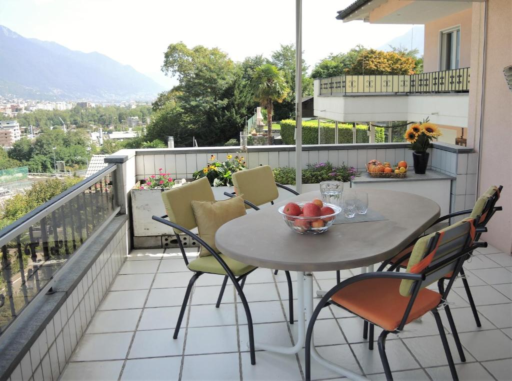 una mesa y sillas en un balcón con vistas en Verena, en Ascona