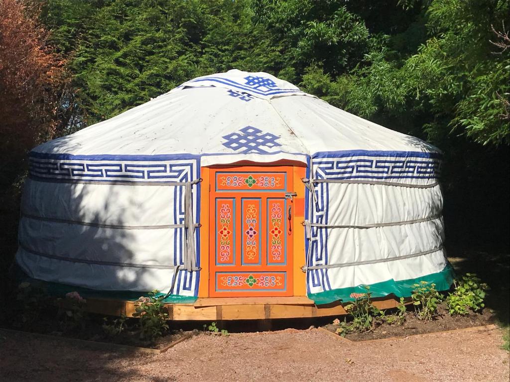 Une maison iguane colorée est installée dans une cour. dans l'établissement yourte Coeur de Combray, à Ernes