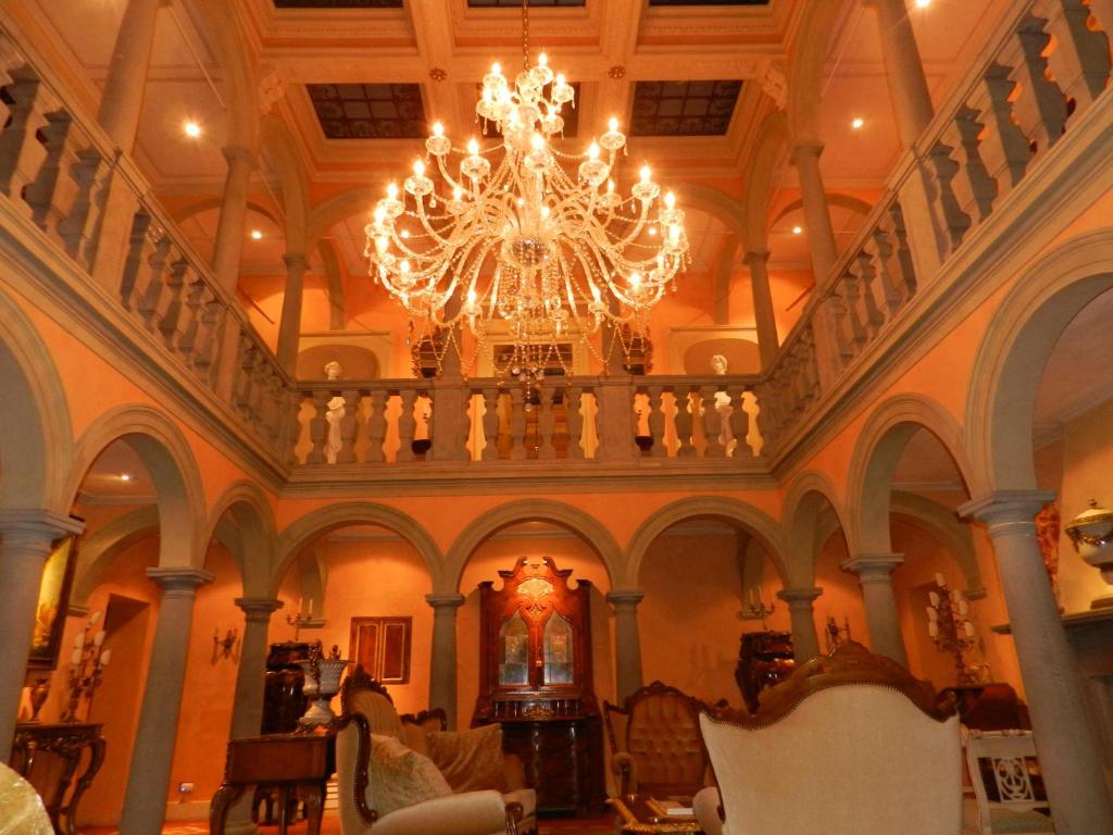 um quarto amplo com um lustre num edifício em Villa Bertagni em Castelnuovo di Garfagnana