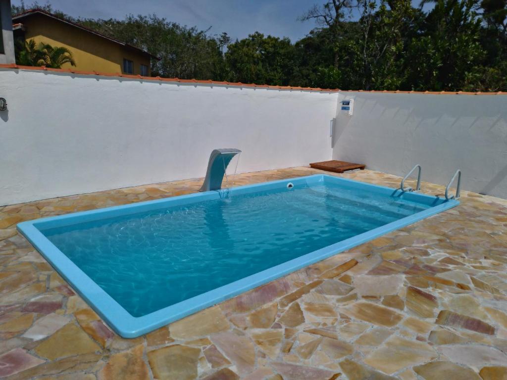 een zwembad met een stoel in het midden bij Bertioga-Costa do Sol MK9 in Praia Guaratuba