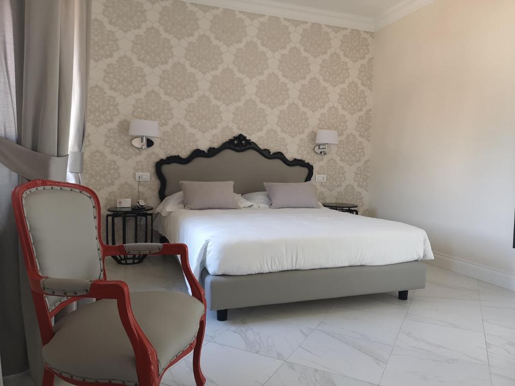 a bedroom with a white bed and a chair at Hotel Altavilla Catanzaro in Catanzaro