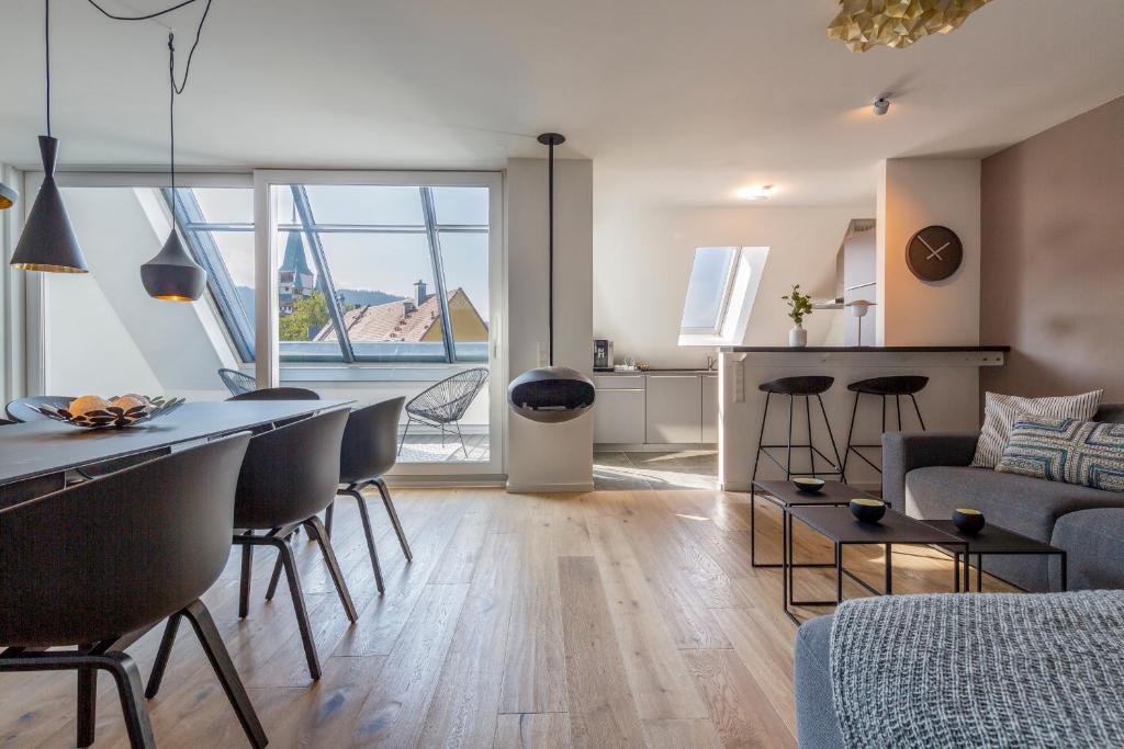a kitchen and living room with a table and chairs at cosy grey apartments in Freiburg im Breisgau