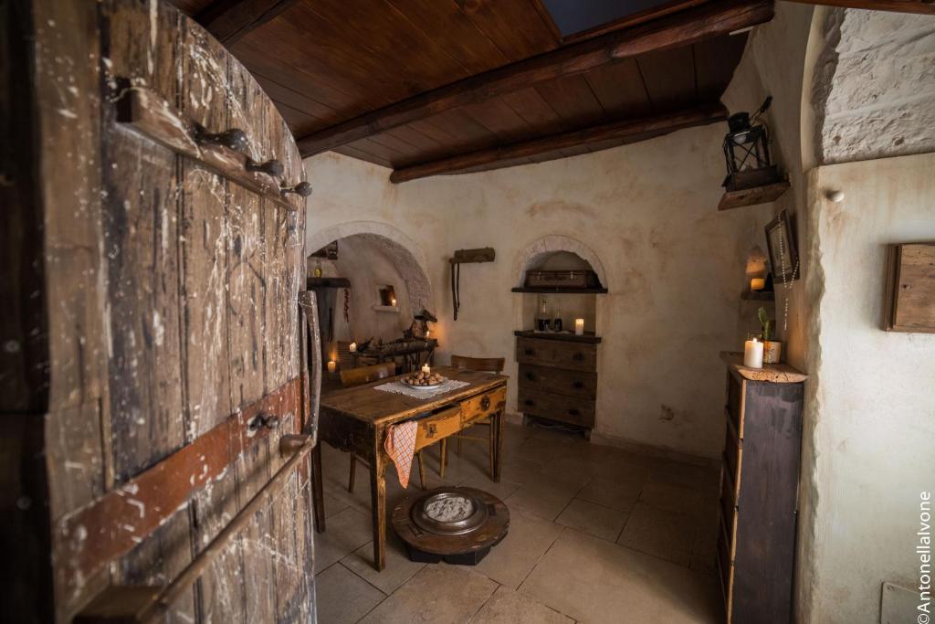 eine Küche mit einem Tisch und einem Waschbecken in einem Zimmer in der Unterkunft Rione Pentimi in Alberobello