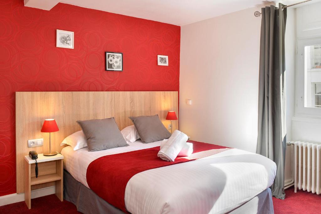 - une chambre avec un grand lit et un mur rouge dans l'établissement Logis Hôtel Restaurant Le Puits Doré, à Richelieu