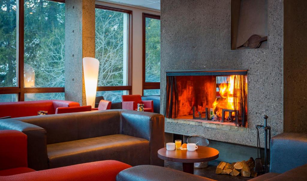 a living room with a fireplace and couches at Hôtel Club mmv Le Flaine *** in Flaine