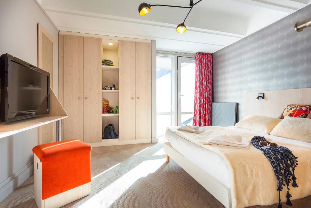 a bedroom with a bed and a tv in it at Hôtel Club mmv Le Flaine *** in Flaine