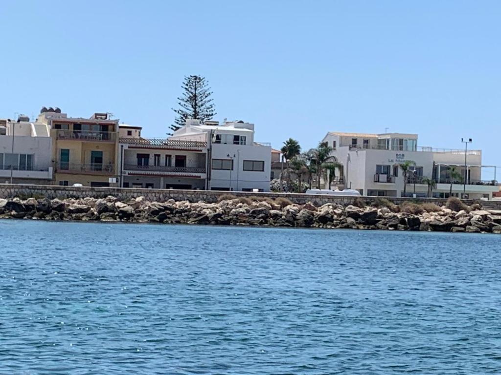 a group of houses on the shore of a body of water at Amareilmare2 in Marzamemi