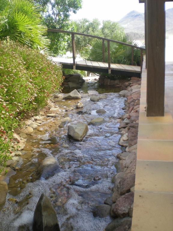 a bridge over a stream with rocks and a river gmaxwell gmaxwell gmaxwell gmaxwell at Hostal El Dorado in San José