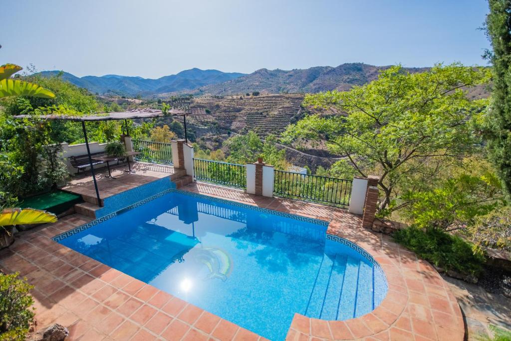 una piscina con vista sulle montagne di Cubo's Casa Rural Jacaranda a Guaro