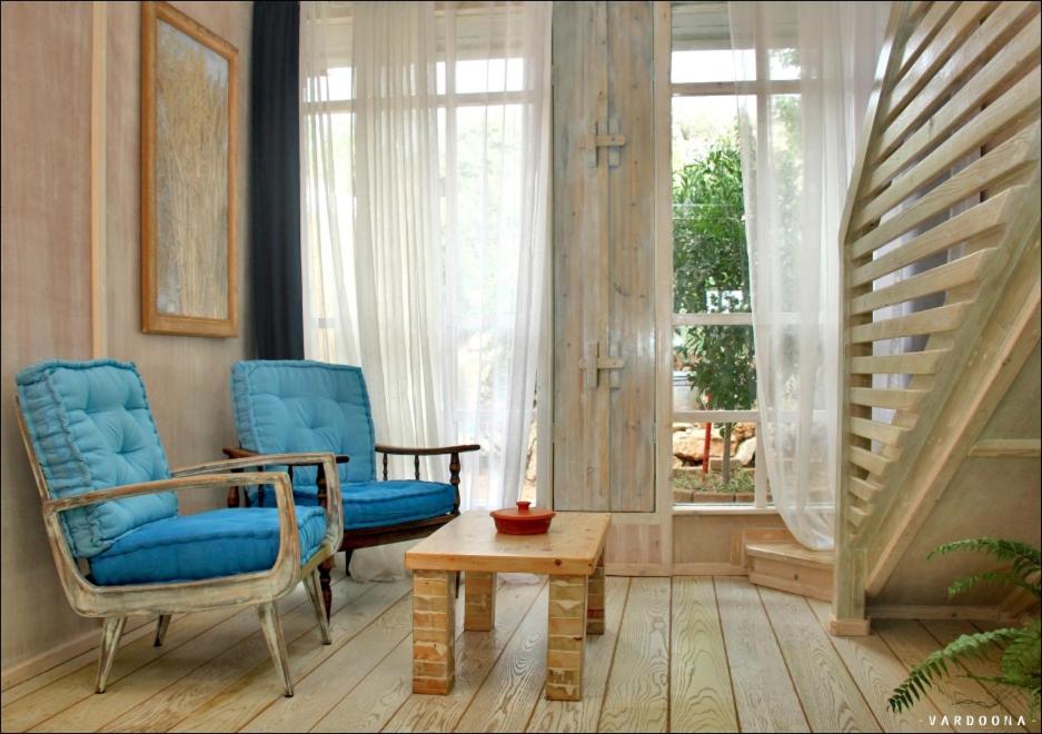 un soggiorno con due sedie, un tavolo e una finestra di Vitals On the Mountain in Katzir a Katzir 