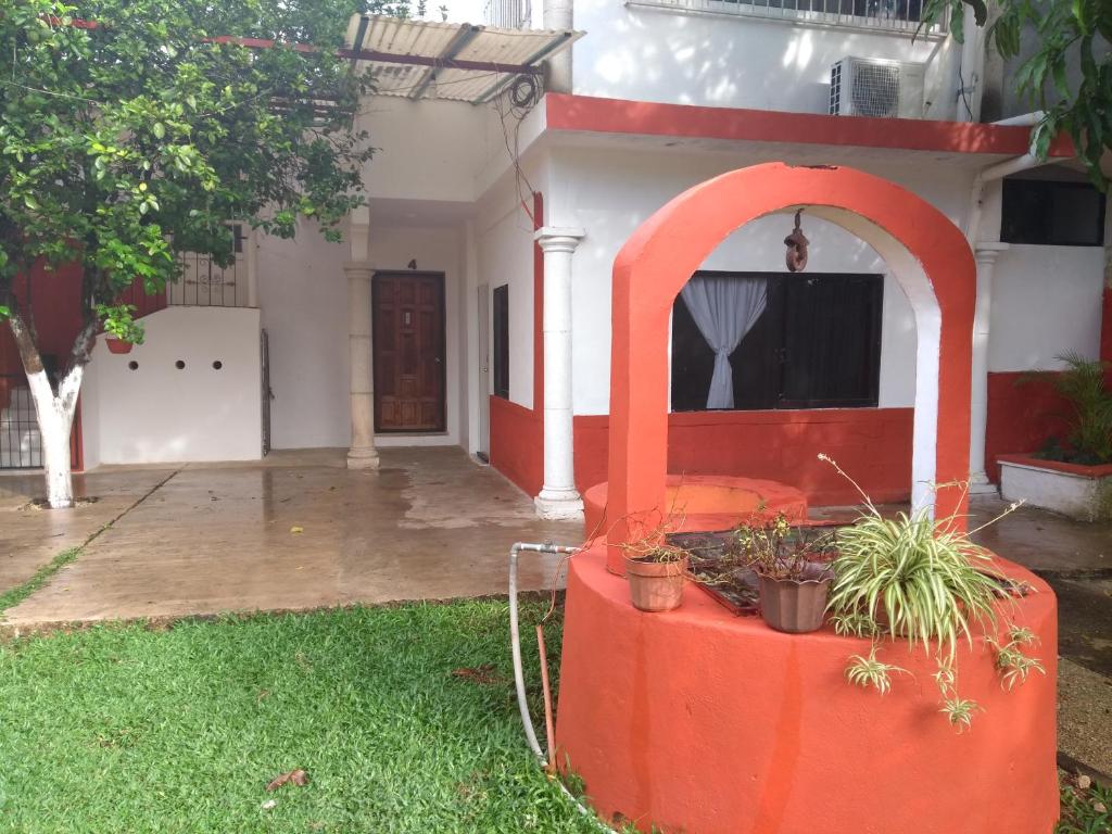 a house with an orange structure in the yard at Hospedaje Papagrande in Homún
