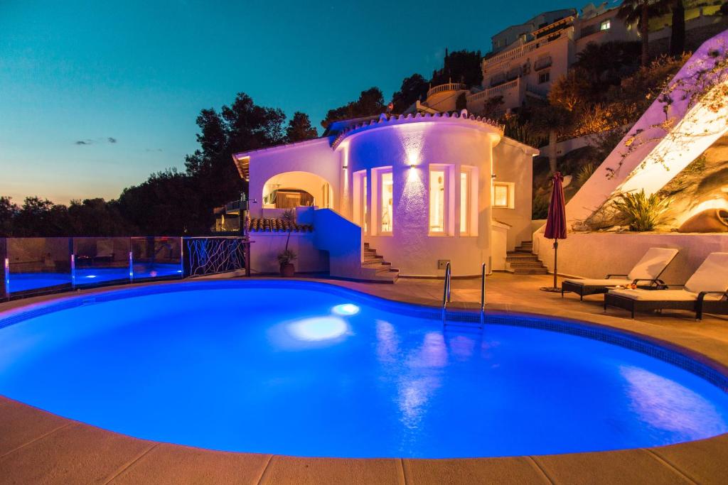 een zwembad voor een huis 's nachts bij Casa Infinidad in Moraira