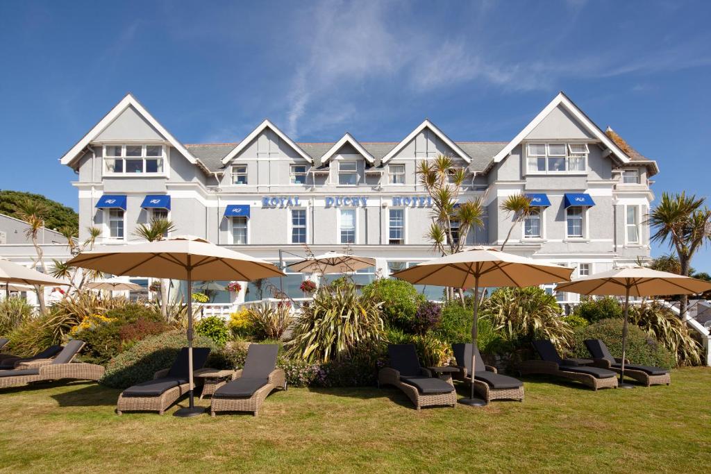 a large white building with chairs and umbrellas at The Royal Duchy Hotel in Falmouth