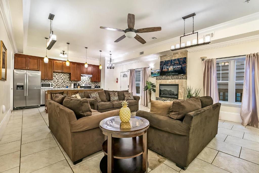 a living room with two couches and a kitchen at Spacious 4BR City Condo steps from St Charles Ave in New Orleans