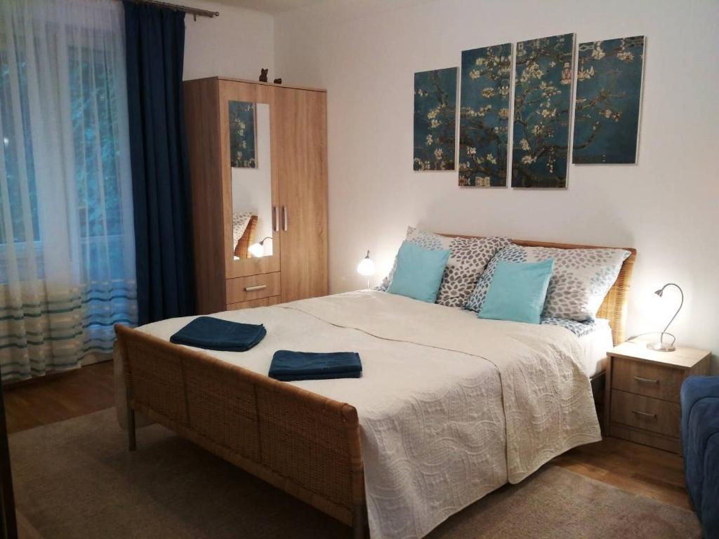 ein Schlafzimmer mit einem großen Bett mit blauen Kissen darauf in der Unterkunft Zsuzsa Apartman in Budapest
