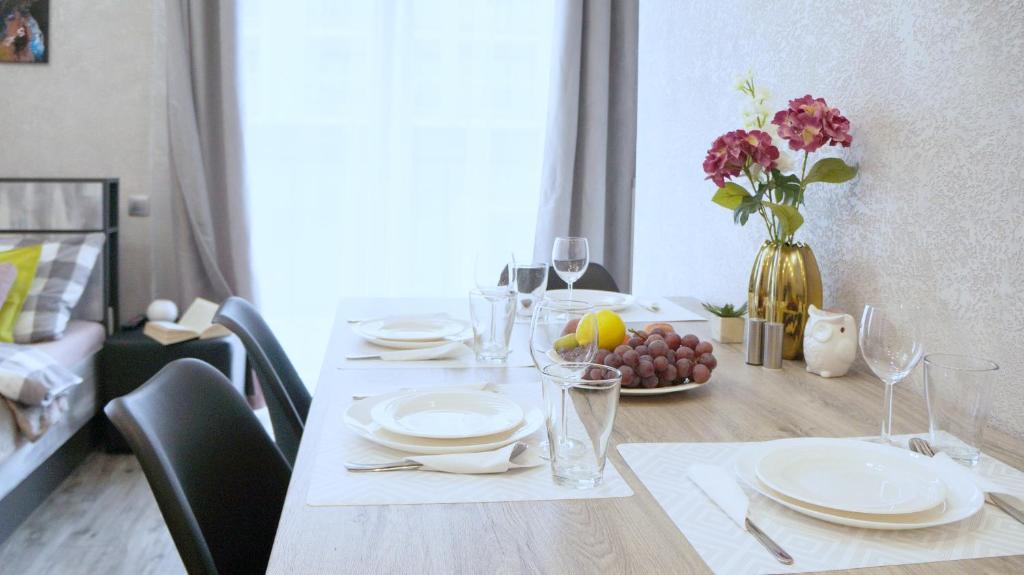 a dining room table with plates and a vase of flowers at Art Apartments II in Wrocław