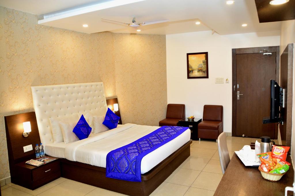 ラクナウにあるHotel Surya Internationalの大きなベッドと机があるホテルの部屋