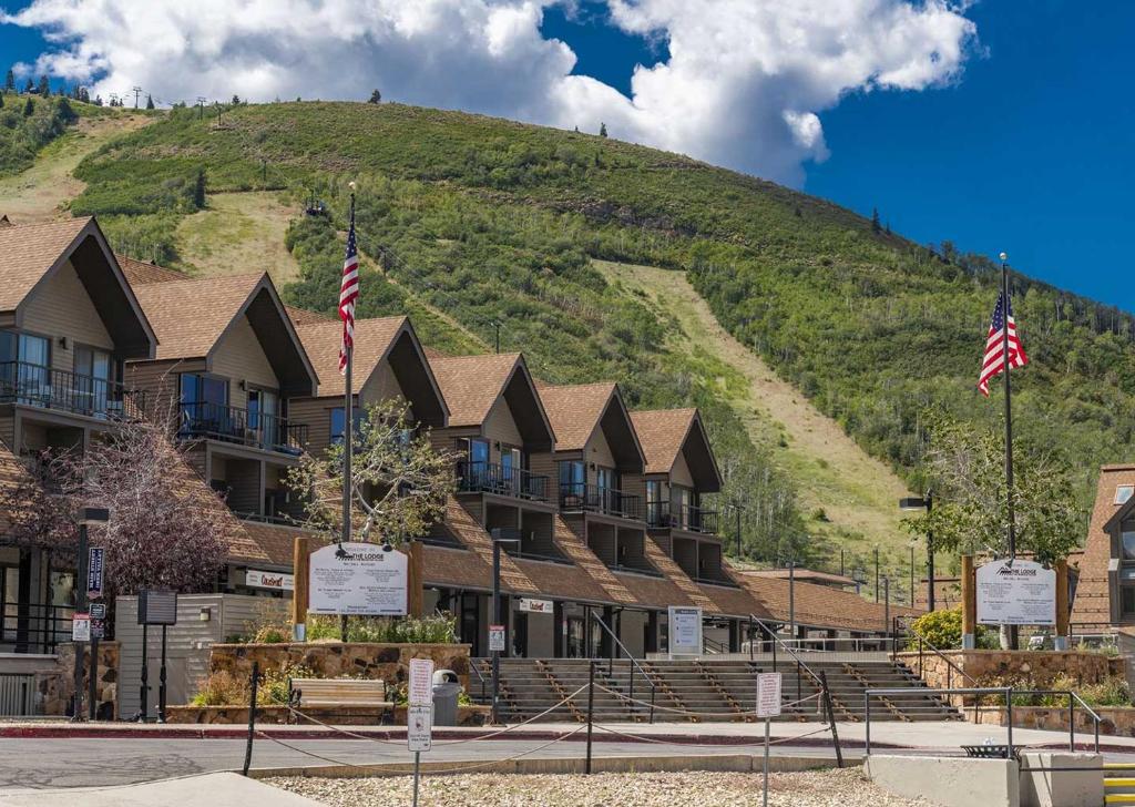 a building with a hill in the background at The Lodge at the Mountain Village in Park City