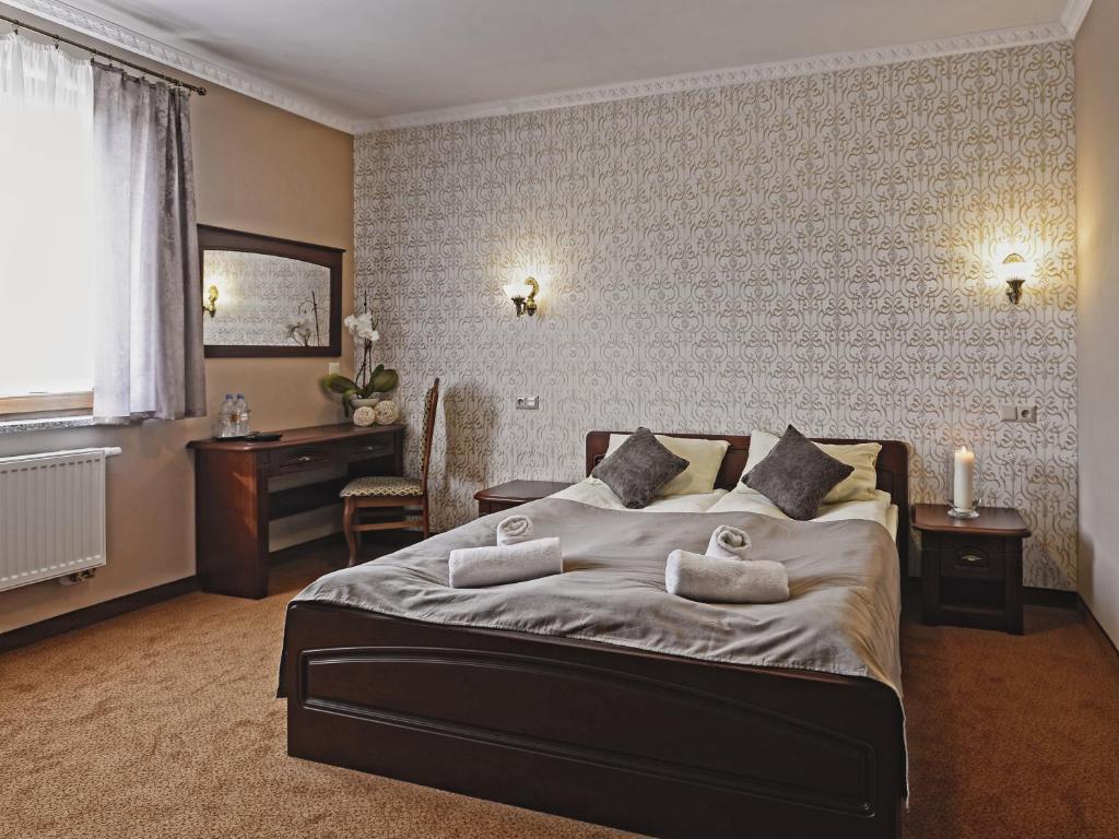 a bedroom with a large bed and a desk at Hotel & Restauracja Stylowa in Namysłów