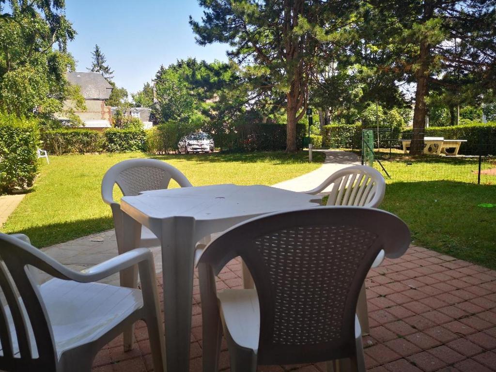een witte tafel en stoelen op een bakstenen patio bij Le Studio De Deauville Plage in Deauville