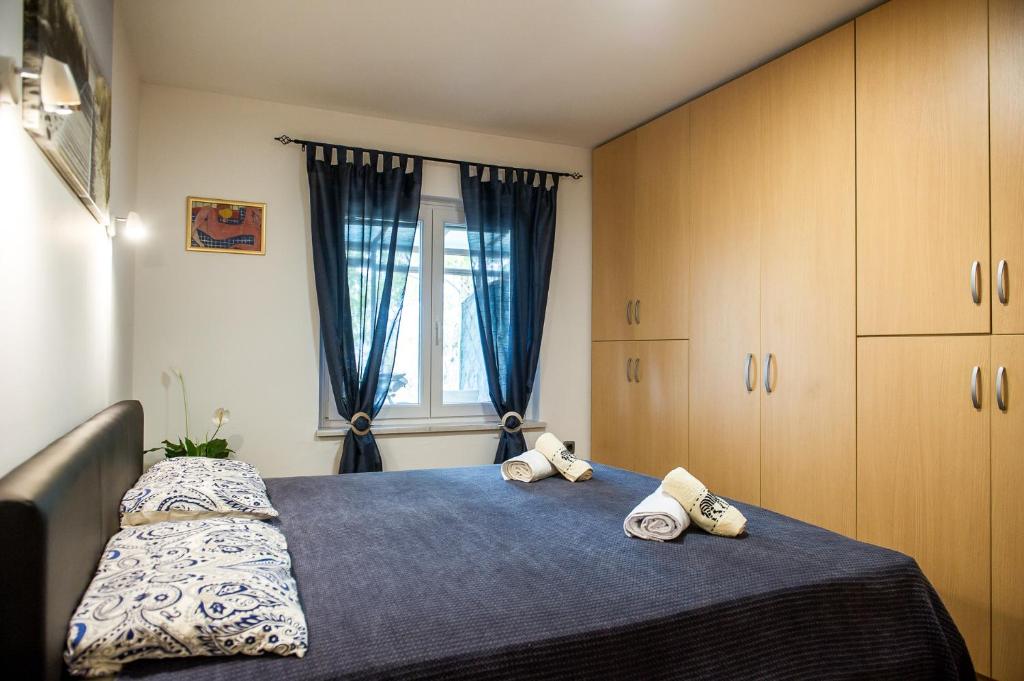 um quarto com uma cama com duas almofadas e uma janela em Apartma soline Seča em Portorož