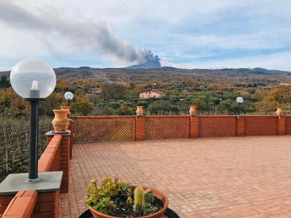 a balcony with a view of a fire in the distance at Camia Etna House in Piedimonte Etneo